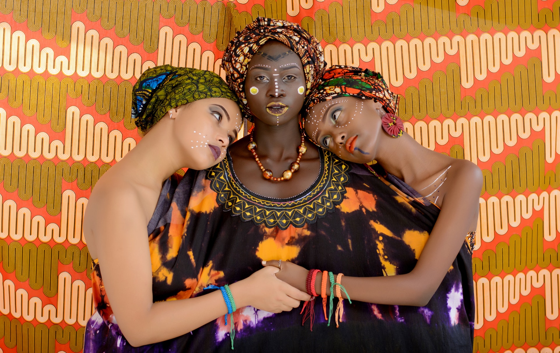 Image d'un trio de femme sur fond ethnique, illustrant la diversité de l'offre Team Building culturel.